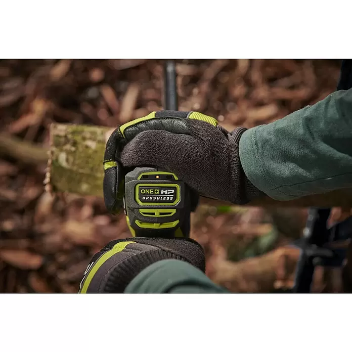 Ryobi ONE+HP Akku-Astsäge RY18PSX15A-120T - 18 V, 2 Ah, Li-Ionen, 1 Akku, Schwertlänge: 15 cm - Person in Handschuhen hält ein schwarz-limettengrünes Ryobi ONE+ HP Brushless Werkzeug, Kontrollleuchte an.