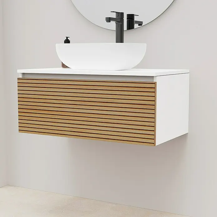 Artysan Conjunto de mueble de baño Osaka Top 1C - Ancho: 80 cm, Blanco/Nogal, 3 pzs. - Un tocador moderno con un lavabo sobre encimera blanco y un frente de listones de madera. El grifo es negro y un espejo redondo cuelga encima.