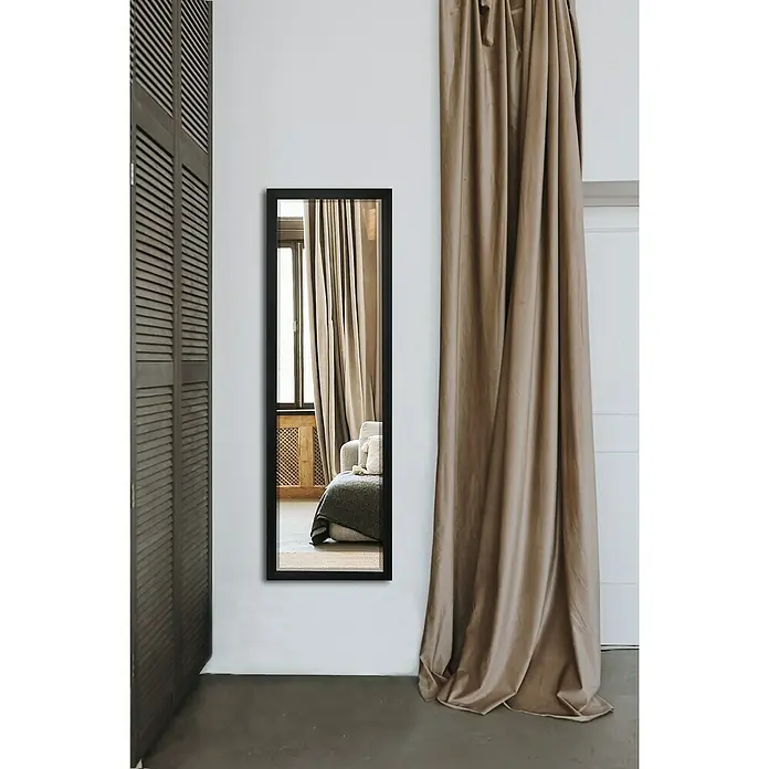 Rahmenspiegel Juliette - 50 x 150 cm, Schwarz, Metall - Ein langer, schmaler Spiegel mit schwarzem Rahmen reflektiert ein Wohnzimmer mit Couch und Vorhängen.