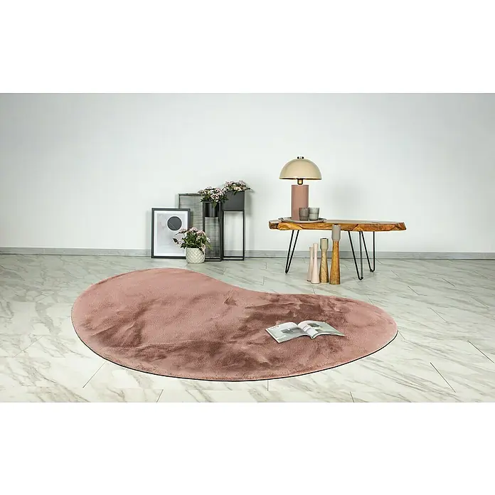 Fellteppich Happy - Rosa, 230 x 160 cm, Oval, 100 % Polyester (Flor) - Ein rosafarbener, herzförmiger Teppich liegt auf einem Marmorboden, mit einer Zeitschrift darauf, für eine gemütliche Atmosphäre im Raum.