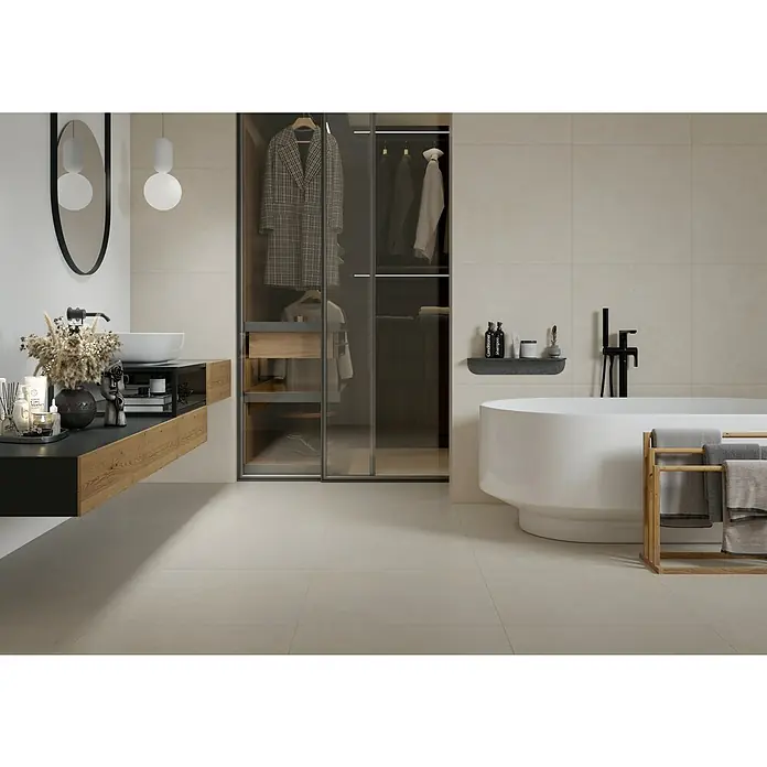 Feinsteinzeugfliese Big Sand - 60 x 60 cm, Beige, Matt - Modernes Badezimmer mit freistehender Badewanne, Waschtisch und begehbarem Kleiderschrank in einem stilvollen Design.