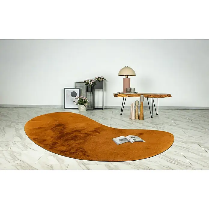 Fellteppich Happy - Amber, 230 x 160 cm, Oval, 100 % Polyester (Flor) - Ein orangefarbener, flauschiger Teppich liegt auf einem Marmorboden und verleiht dem Raum Wärme und Komfort.