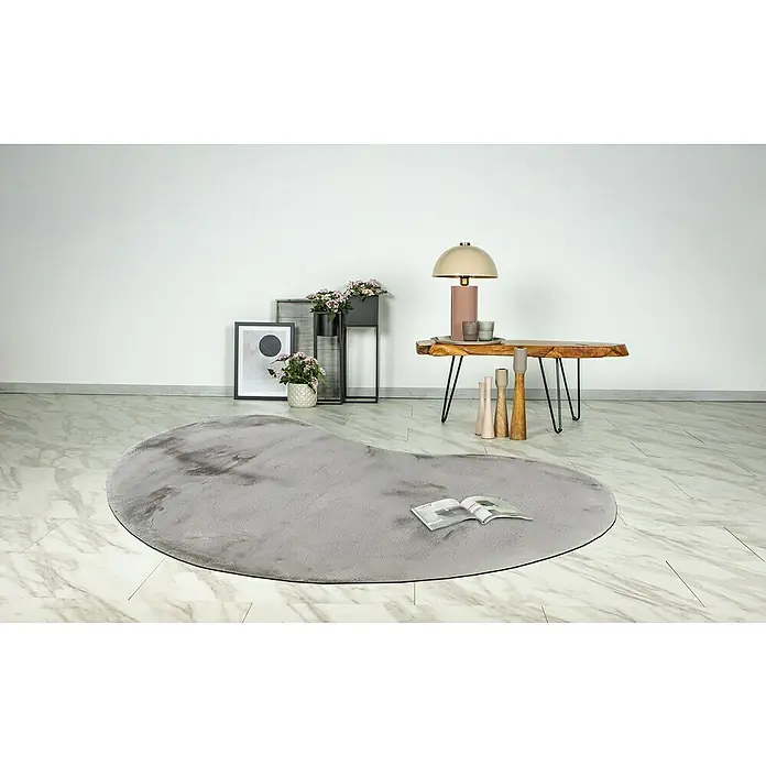 Fellteppich Happy - Silber, 230 x 160 cm, Oval, 100 % Polyester (Flor) - Ein grauer, herzförmiger Teppich liegt auf einem hellen, marmorierten Boden und sorgt für eine gemütliche Atmosphäre im Raum. Auf dem Teppich liegt ein Buch.