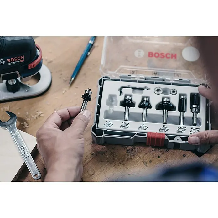 Bosch Fräser-Set Trim&Edging - 6 -tlg., Durchmesser Schaft: 8 mm - Nahaufnahme eines Bosch-Fräser-Sets mit verschiedenen Fräsern, die in einem grauen Kunststoffkoffer mit rotem Verschluss präsentiert werden.