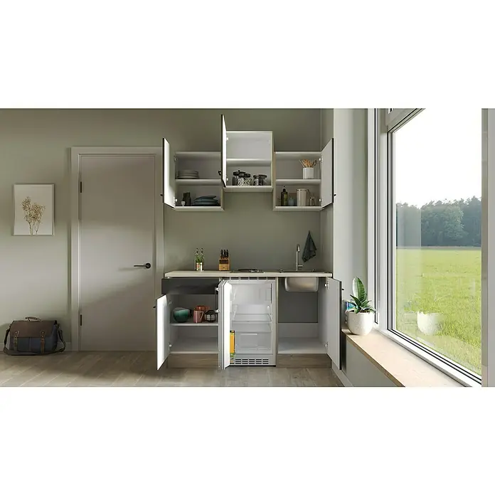 Flex-Well Singleküche Capri - Breite: 150 cm, Schwarz, Mit Elektrogeräten - Küchenzeile mit offenem Kühlschrank, weißen Schränken und Spüle unter einem Fenster mit Blick ins Grüne.