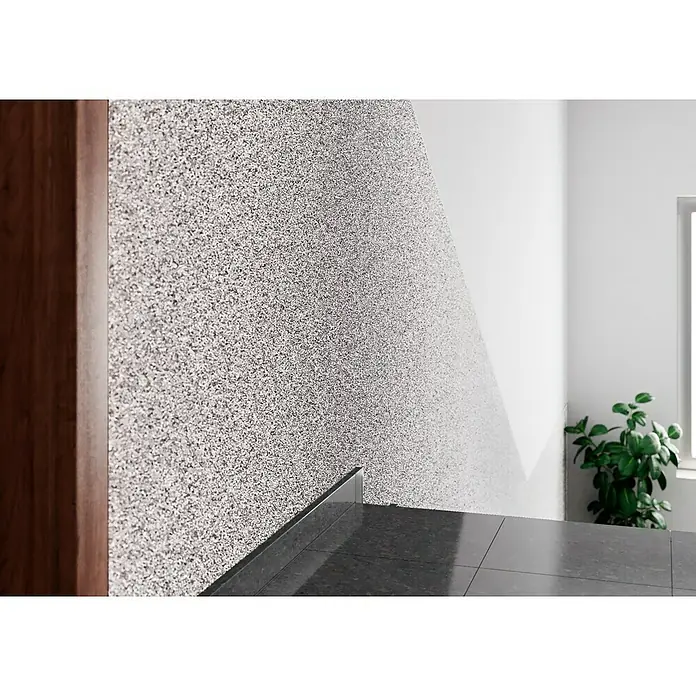 Probau WDVS-Buntsteinputz - Weiß/Schwarz, 25 kg - Detailaufnahme einer Wand mit dekorativem Spritzputz in Grau- und Weißtönen, kombiniert mit einem hellen Anstrich. Elegantes Innendesign mit Akzenten.