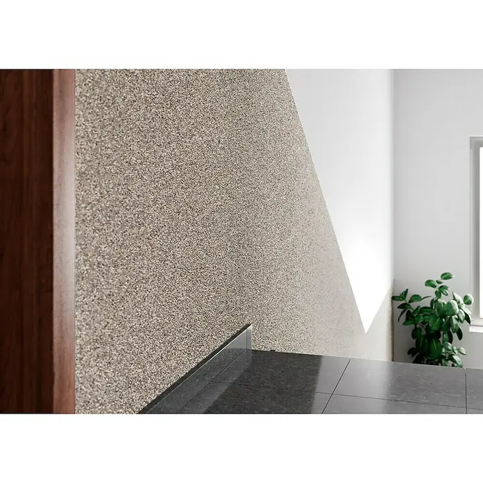 swingcolor Buntsteinputz - Korngröße: 2 - 3 mm, 20 kg, Nr. 51 - Nahaufnahme einer Wand mit dekorativem Putz und angrenzenden Bodenfliesen. Ein Holztürrahmen ist ebenfalls sichtbar.