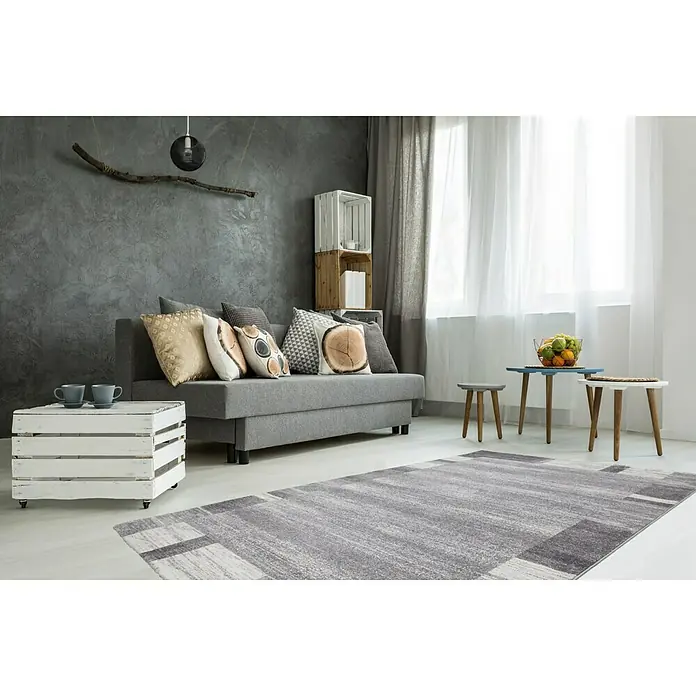 Kurzflorteppich Feeling 500 - Silber, 290 x 200 cm, 100 % Polypropylen (Flor) - Ein modernes Wohnzimmer mit einem grauen Sofa, einem Couchtisch und einem geometrischen Teppich.