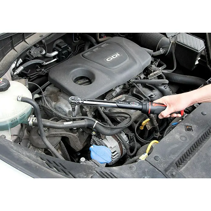 Wisent Drehmomentschlüssel - ⅜″, 10 Nm - 60 Nm - Detailaufnahme eines Wisent Drehmomentschlüssels, der an einem Motorblock in einer Werkstatt verwendet wird.