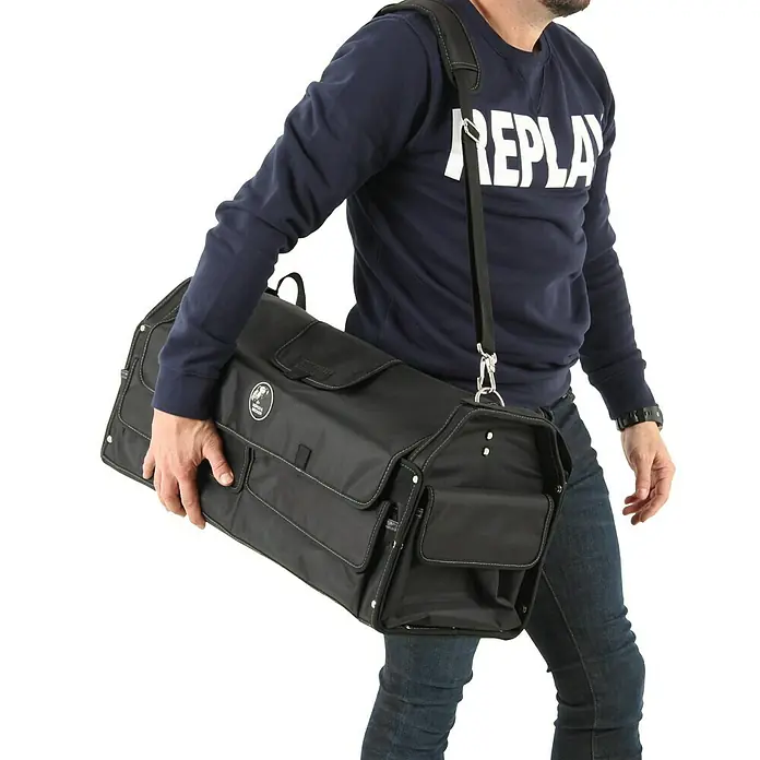 Hepco & Becker Werkzeugtasche Profi-Installateurtasche 5857 - L x B x H: 290 x 620 x 310 mm, Polyester - Eine Person trägt eine schwarze Tragetasche über der Schulter, ideal für den Transport von Ausrüstung. Die Tasche verfügt über mehrere Fächer.