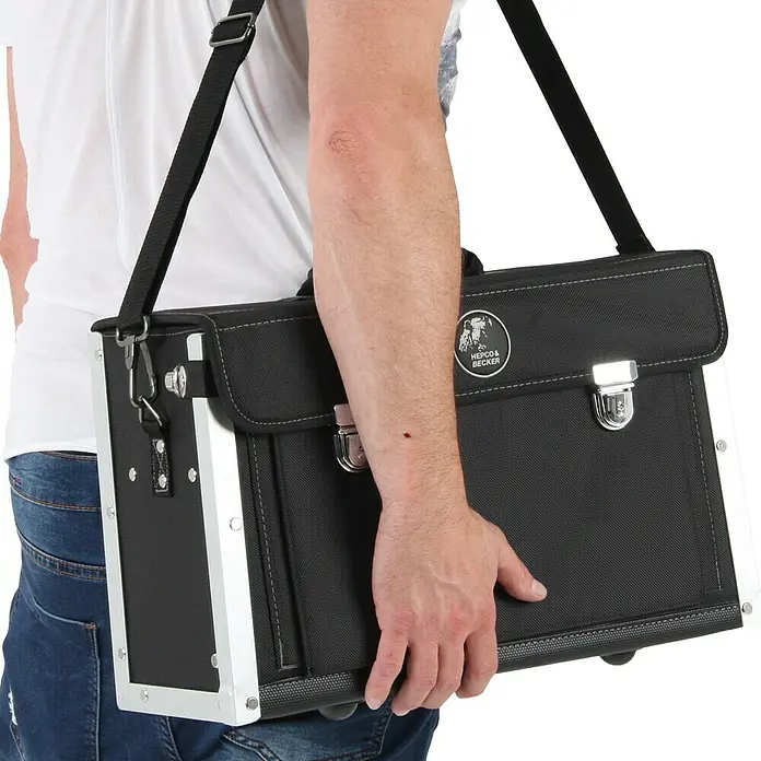 Hepco & Becker Werkzeugtasche Polytex Lehrlingstasche 5863 - L x B x H: 150 x 450 x 250 mm, Polyester - Eine Person trägt eine Hepco & Becker Werkzeugtasche mit Schultergurt, ideal für den mobilen Einsatz und sichere Aufbewahrung von Werkzeugen.