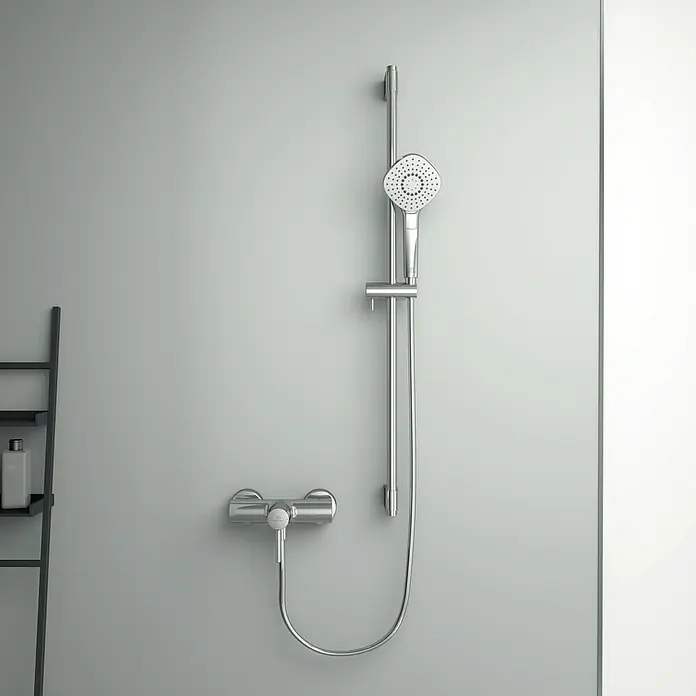 Ideal Standard Ceraline Brausearmatur - Chrom, Glänzend - Eine Chrom-Duschgarnitur mit quadratischem Duschkopf und Armatur an einer grauen Wand für ein modernes Badezimmerdesign.
