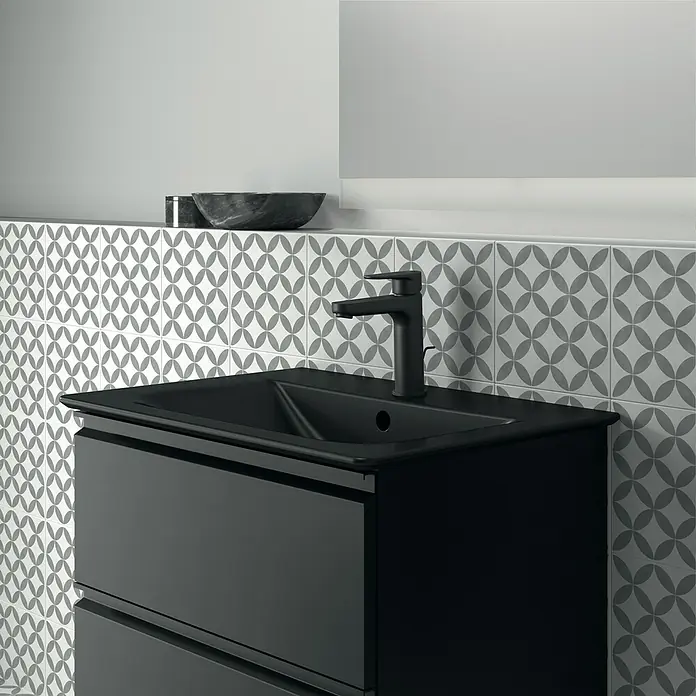 Ideal Standard Connect Air Einbauwaschbecken - 64 x 46 cm, Ohne Spezialglasur, Hahnloch: Mitte, Mit Überlauf, Schwarz - Elegantes schwarzes Badezimmerwaschbecken mit modernem Design und passender Armatur vor gemusterten Fliesen.