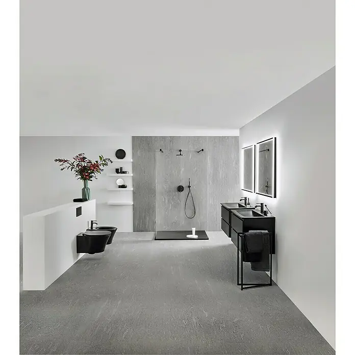 Ideal Standard Connect Air Einbauwaschbecken84 x 46 cm, Ohne Spezialglasur, Hahnloch: Mitte, Mit Überlauf, Schwarz - Elegantes Badezimmerdesign mit schwarzen Armaturen, Waschtisch und stilvoller Dusche vor einer grauen Wand. Das moderne Flair wird durch Beleuchtung akzentuiert.