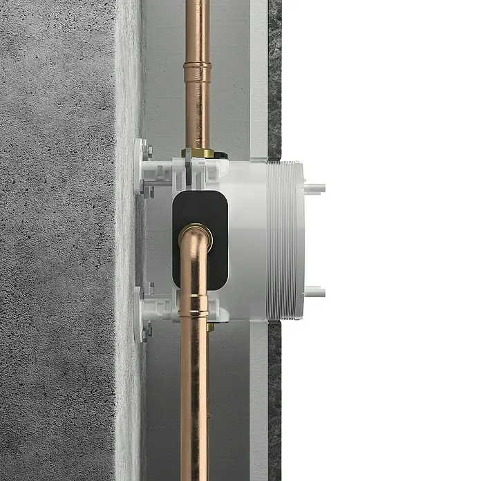 Ideal Standard Unterputzsystem Easy-Box - Einbautiefe: 73 mm - 95 mm - Nahaufnahme eines eingebauten Wasserhahn-Anschlusskastens mit Kupferrohren an einer Betonwand.