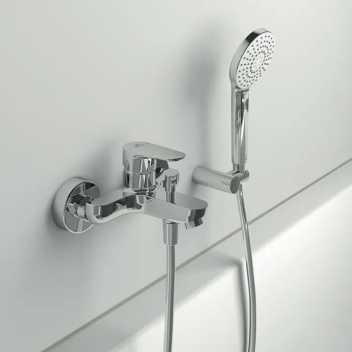 Ideal Standard Cerafine O Badewannenarmatur - Ausladung Armatur: 155 mm, Chrom, Glänzend - Abgebildet ist eine glänzende Chrom-Badewannenarmatur mit Handbrause an einer weißen Wand, die ein modernes und minimalistisches Design aufweist.