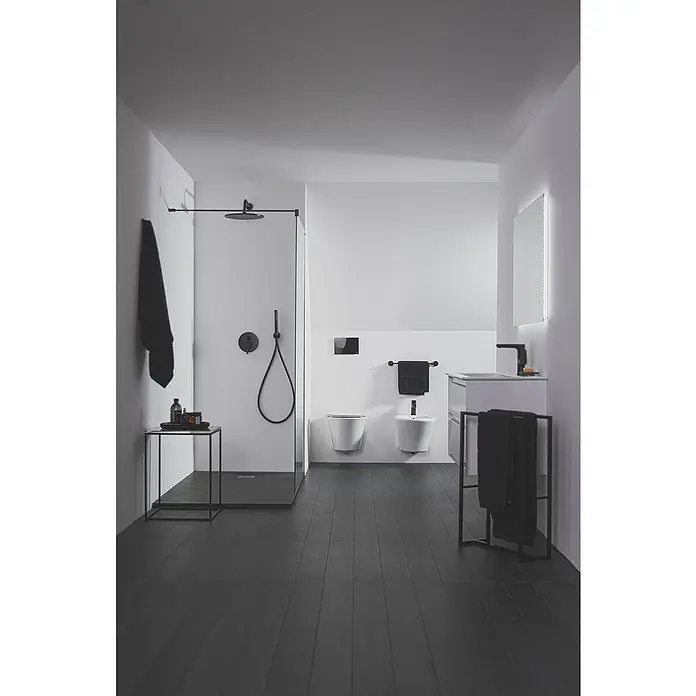 Ideal Standard Cerafine O Waschtischarmatur H155 - Schwarz, Matt, Ohne Ablaufgarnitur - Modernes Badezimmer in Schwarzweiß mit einer begehbaren Dusche, Toilette, Bidet und einem beleuchteten Spiegel. Die Armaturen sind in Schwarz gehalten.