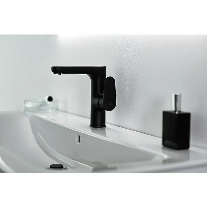 Ideal Standard Cerafine O Waschtischarmatur H155 - Schwarz, Matt, Ohne Ablaufgarnitur - Nahaufnahme einer stilvollen, mattschwarzen Armatur auf einem modernen Waschbecken, ergänzt durch eine elegante Seifenspenderflasche.
