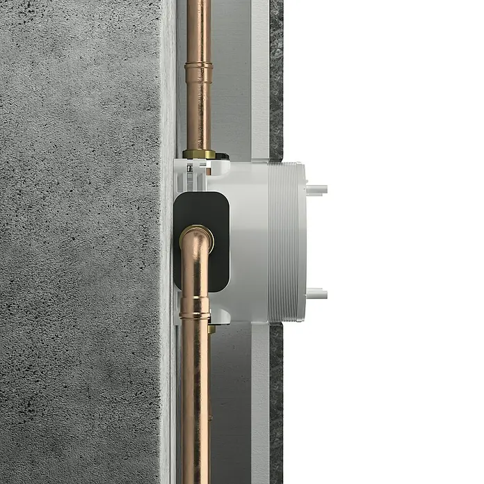 Ideal Standard Unterputzsystem Easy-Box - Einbautiefe: 73 mm - 95 mm - Nahaufnahme eines Unterputz-Thermostat-Mischers mit Kupferrohren, der in einer Wand installiert ist. Ideal für moderne Badezimmerdesigns.