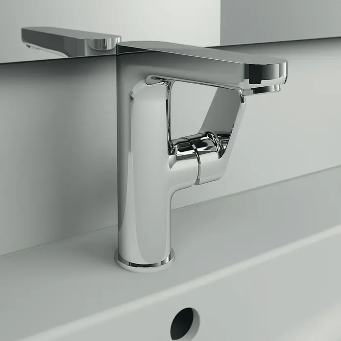 Ideal Standard Cerafine O Waschtischarmatur H155 - Chrom, Glänzend, Mit Ablaufgarnitur - Nahaufnahme eines modernen Chrom-Waschtischhahns auf einem weißen Waschbecken mit einem Spiegel, der das Design widerspiegelt.