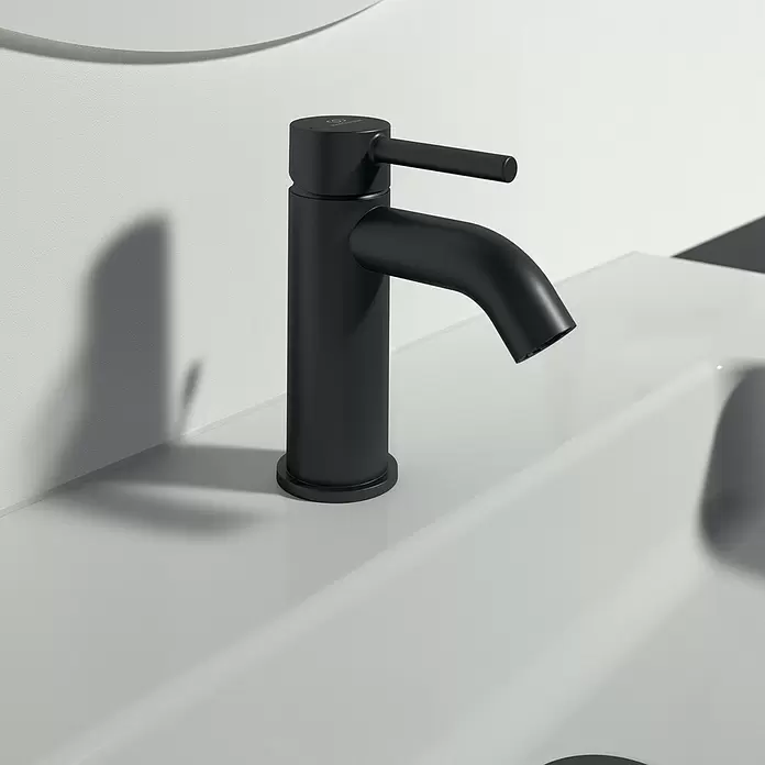 Ideal Standard Ceraline Grifo de lavabo - Negro, Mate, Con juego de desagüe - Grifo monomando negro mate sobre un lavabo de baño blanco.