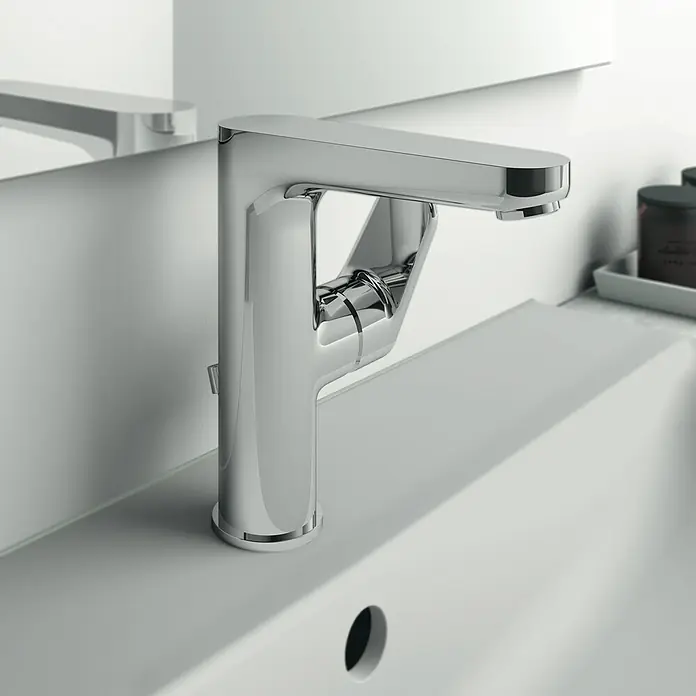 Ideal Standard Cerafine O Waschtischarmatur H155 - Chrom, Glänzend, Mit Ablaufgarnitur - Nahaufnahme eines modernen, verchromten Wasserhahns auf einem weißen Waschbecken, der das elegante Design und die glänzende Oberfläche hervorhebt.