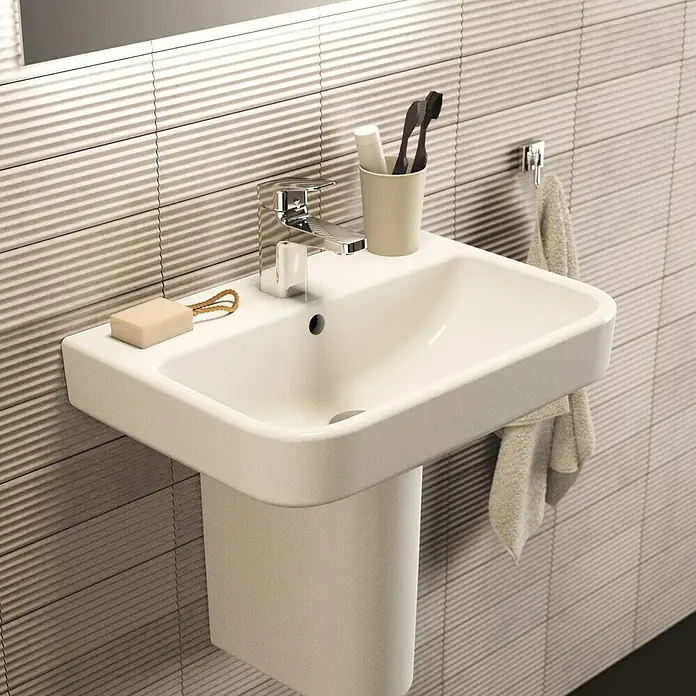 Ideal Standard i.life S Waschtisch - 55 x 38 cm, Ohne Spezialglasur, Hahnloch: Mitte, Mit Überlauf, Weiß - Ein stilvolles Waschbecken mit Seife, Zahnbürste und Handtuch. Ideal für moderne Badezimmer, das Waschbecken bietet Funktionalität und elegantes Design.