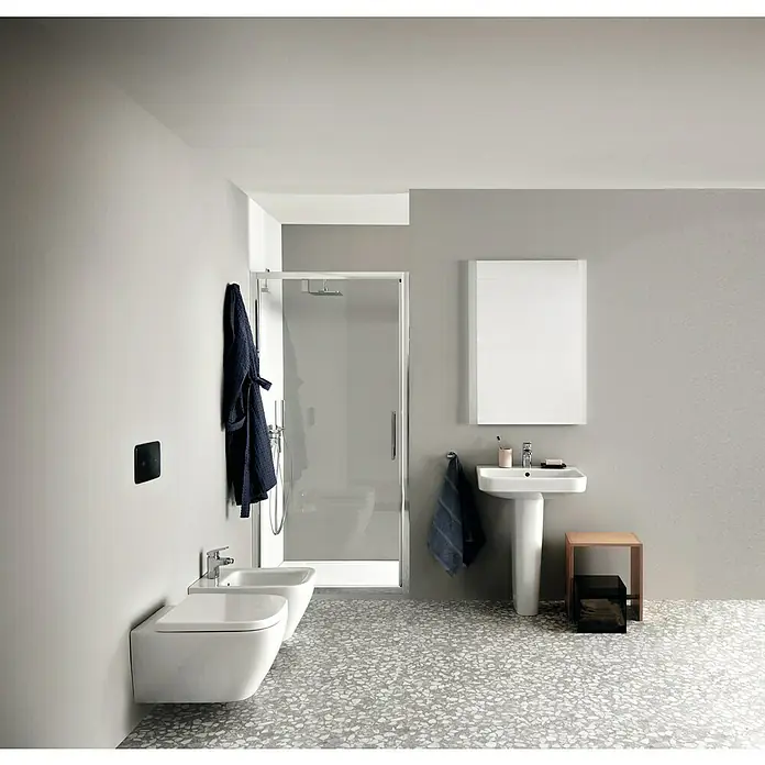 Ideal Standard i.life S Waschtisch - 55 x 38 cm, Ohne Spezialglasur, Hahnloch: Mitte, Mit Überlauf, Weiß - Modernes Badezimmer mit weißem Waschbecken, Bidet und einer Dusche mit Glasabtrennung für ein minimalistisches Ambiente.