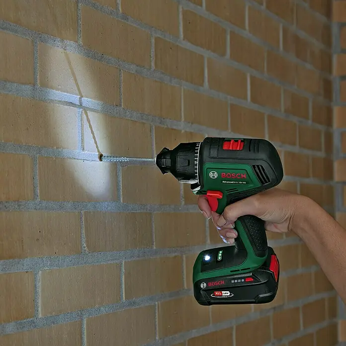 Bosch Power for All 18V Akku-Bohrschrauber AdvancedDrill 18V-80 QuickSnap - 18 V, Ohne Akku, 78 Nm, 3 Aufsätze - Bohrmaschine bei der Arbeit. Akkuschrauber von Bosch beim Schrauben in eine Ziegelwand mit integriertem Licht.