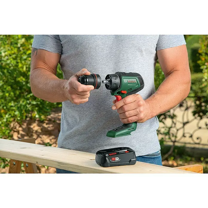 Bosch Power for All 18V Akku-Bohrschrauber AdvancedDrill 18V-80 Quick Snap - 18 V, Ohne Akku, 78 Nm - Ein Mann wechselt den Aufsatz an einem grünen Bosch Akku-Bohrschrauber AdvancedDrill 18V-80, daneben liegt ein Akku.