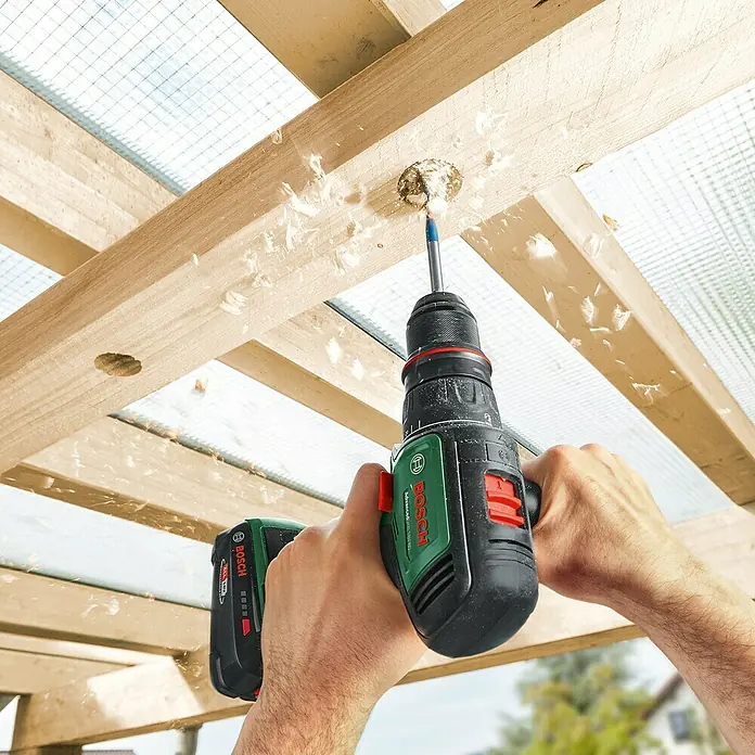 Bosch Power for All 18V Akku-Bohrschrauber AdvancedDrill 18V-80 QuickSnap - 18 V, 1 Akku, 2,5 Ah, 78 Nm - Akku-Bohrschrauber von Bosch in Aktion, der ein Loch in ein Holzbrett bohrt. Holzspäne fliegen umher.