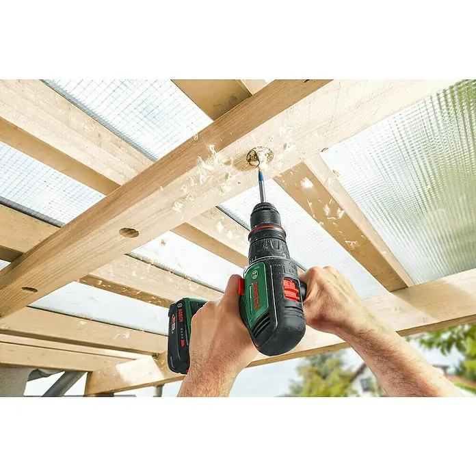 Bosch Power for All 18V Akku-Bohrschrauber AdvancedDrill 18V-80 QuickSnap - 18 V, Ohne Akku, 78 Nm, 3 Aufsätze - Ein Bosch Akkuschrauber wird benutzt, um ein Loch in eine Holzkonstruktion zu bohren. Späne fliegen während des Bohrvorgangs.