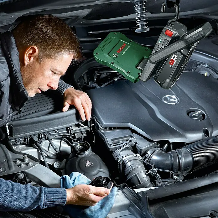 Bosch Power for All 18V Akku-Lampe Easy SpotLight 18V-400 - 18 V, Ohne Akku, 3 Helligkeitsstufen - Ein Mann, der unter der Motorhaube eines Autos arbeitet, mit Bosch-Leuchten für eine gute Ausleuchtung.