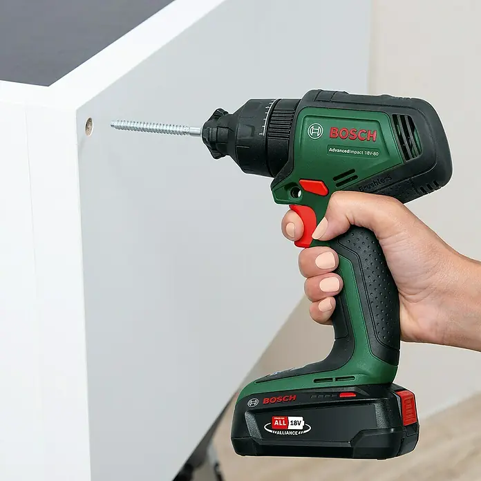 Bosch Power for All 18V Akku-Schlagbohrschrauber Advanced Impact 18V-80 QuickSnap - 18 V, Ohne Akku, 82 Nm, 3 Aufsätze - Bosch AdvancedImpact 18V-80 Akku-Schlagschrauber mit Schraube vor einem weißen Schrank. Das Gerät ist in Grün und Schwarz gehalten.