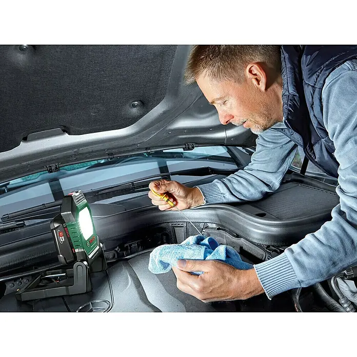 Bosch Power for All 18V Akku-Lampe UniversalWorkLight 18V-2100 - 18 V, Ohne Akku, 3 Helligkeitsstufen - Wartung eines Autos mit einer Bosch Akku-Arbeitsleuchte, die das Motorfach hell ausleuchtet.