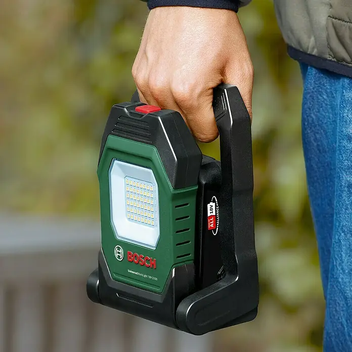 Bosch Power for All 18V Akku-Lampe UniversalWorkLight 18V-2100 - 18 V, Ohne Akku, 3 Helligkeitsstufen - Eine Nahaufnahme einer Bosch UniversalWorkLight 18V-2100 Akku-Arbeitsleuchte, die von einer Hand gehalten wird.