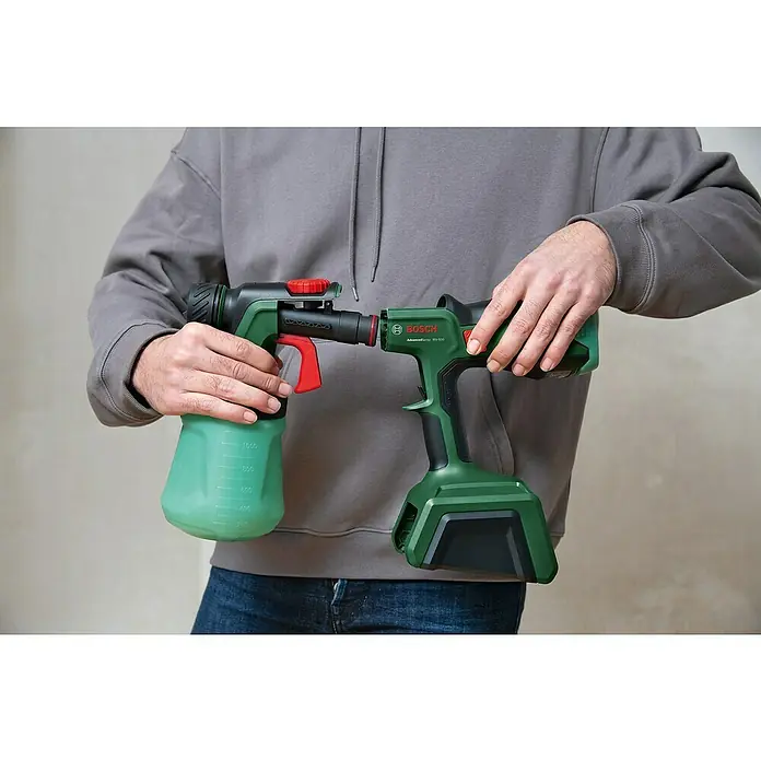 Bosch Power for All 18V Akku-Farbsprühsystem AdvancedSpray 18V-500 - 18 V, Ohne Akku, Max. Fördermenge: 500 l/h - Eine Person hält einen Bosch AdvancedSpray MV 600 Farbspritzpistole, die in zwei Teile geteilt ist, vor einem hellgrauen Hintergrund.