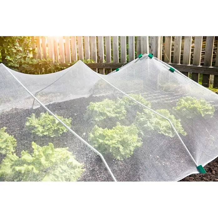 Windhager Insektenschutz-Netz - L x B: 5 x 2 m, Weiß - Bild einer Gemüsegartenabdeckung, die Salat vor Schädlingen schützt, mit einem Netz und grünen Clips über einem erhöhten Beet mit einem Holzzaun.