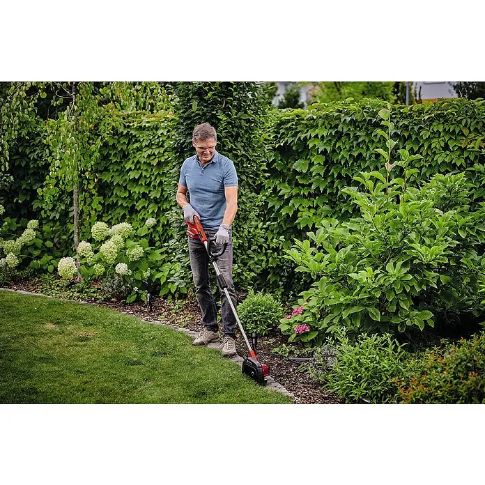 Einhell Power X-Change 18V Rasenkantenschneider GE-LE 18/190 LI - Ohne Akku, 18 V - Mann schneidet mit dem Einhell Akku-Rasentrimmer den Rasen im Garten, umrandet von Grünpflanzen.
