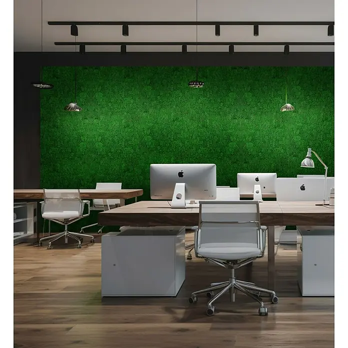Jangal Wandpaneel Modular Wall Moos - Nature Green, 520 x 520 x 30 mm - Modernes Büro mit hellen Schreibtischen, weißen Stühlen und grüner Mooswand. Elegante Beleuchtung sorgt für eine angenehme Arbeitsatmosphäre.