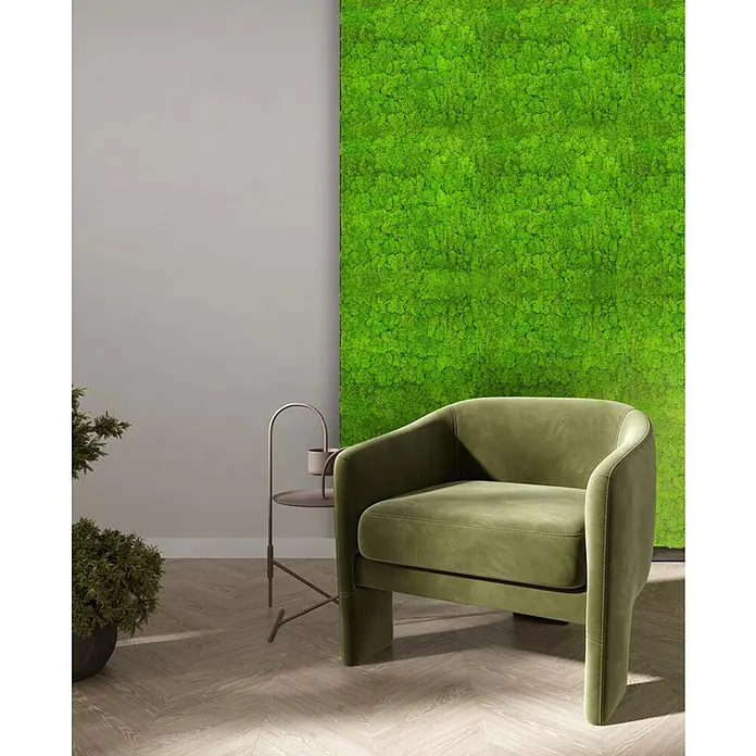 Jangal Wandpaneel Modular Wall Moos - Bright Green, 520 x 520 x 30 mm - Ein grüner Sessel aus Samt steht vor einer Wand mit Moos. Der Sessel ist modern und bequem.