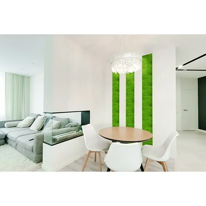 Jangal Wandpaneel Modular Wall Moos - Bright Green, 520 x 520 x 30 mm - Ein stilvolles Esszimmer mit einem runden Holztisch, weißen Stühlen und einer auffälligen Mooswand. Die moderne Pendelleuchte ergänzt das Design.