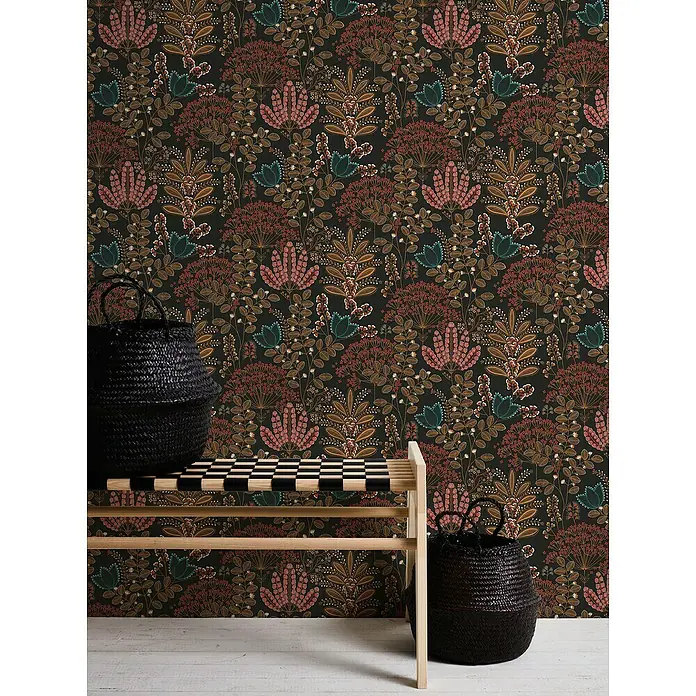 A.S. Création Famous Garden Vliestapete - Schwarz-Bunt-Petrol, Floral, 10,05 x 0,53 m - Ein elegantes Interieur mit einer Bank, auf der ein Korb steht, vor einer floralen Tapete, die eine warme und einladende Atmosphäre schafft.