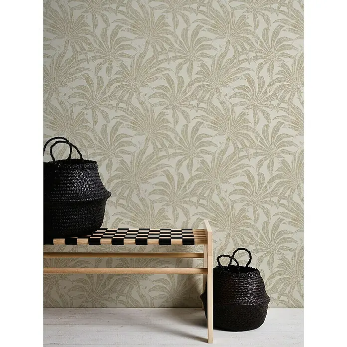 A.S. Création Jade 2 Vliestapete Pflanzen - Beige-Gold-Silber, Floral, 10,05 x 0,53 m - Stilvolle Szene mit geflochtenen Körben und einer Holzbank vor einer Wand mit floralem Muster, die eine einladende Atmosphäre schafft.