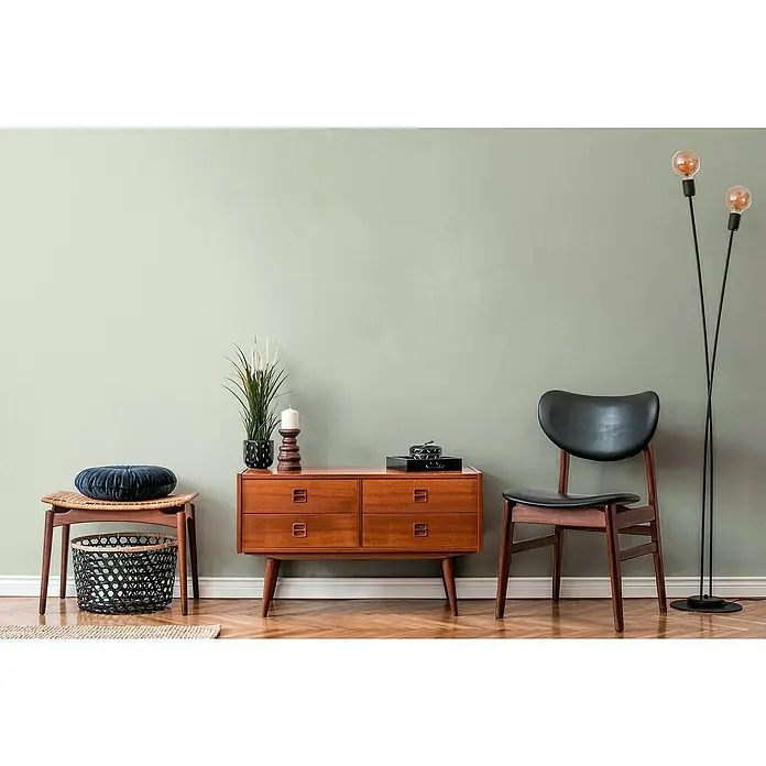 A.S. Création Jade 2 Vliestapete - Pastellgrün, Uni, 10,05 x 0,53 m - Einrichtungsidee mit einer Kommode im Retro-Stil, einem Stuhl und einer Stehlampe. Dekorative Elemente vervollständigen den Look.