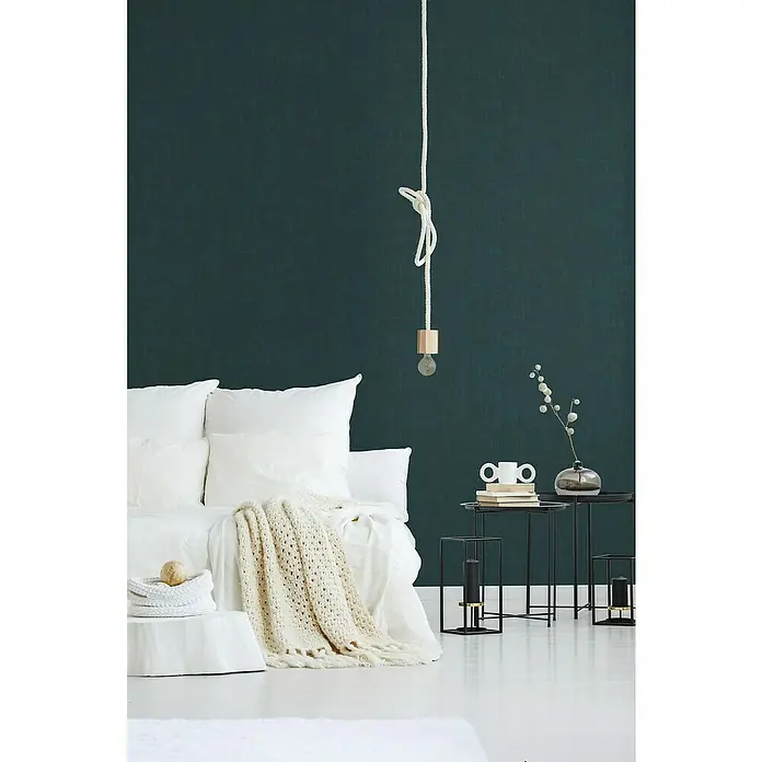 A.S. Création Jade 2 Vliestapete - Dunkles Petrol, Uni, 10,05 x 0,53 m - Elegantes Schlafzimmer mit modernem Nachttisch, stilvoller Lampe und einladendem Bett mit weichen Kissen und Strickdecke für gemütliche Stunden.