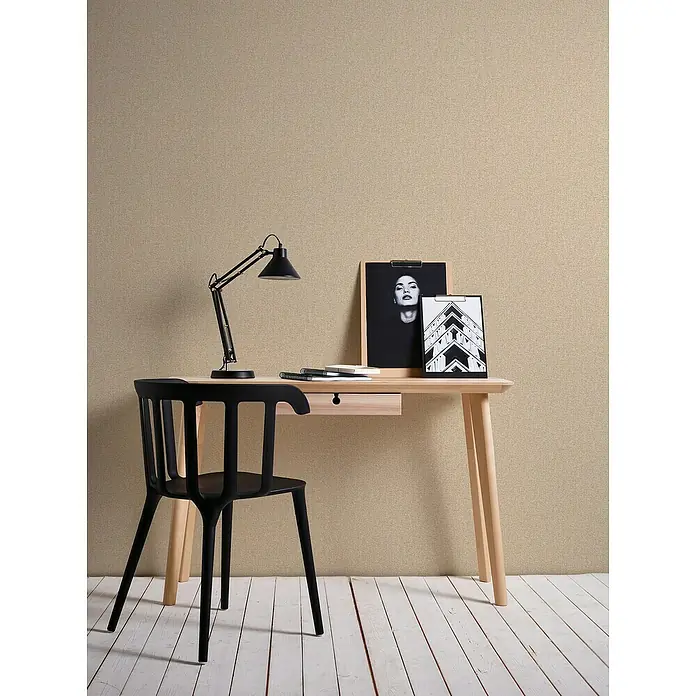 A.S. Création Famous Garden Vliestapete - Beige, Uni, 10,05 x 0,53 m - Elegantes Interieur mit einem hellen Holzschreibtisch mit Schublade, einer schwarzen Lampe und einem schwarzen Stuhl vor einer beigen Wand.