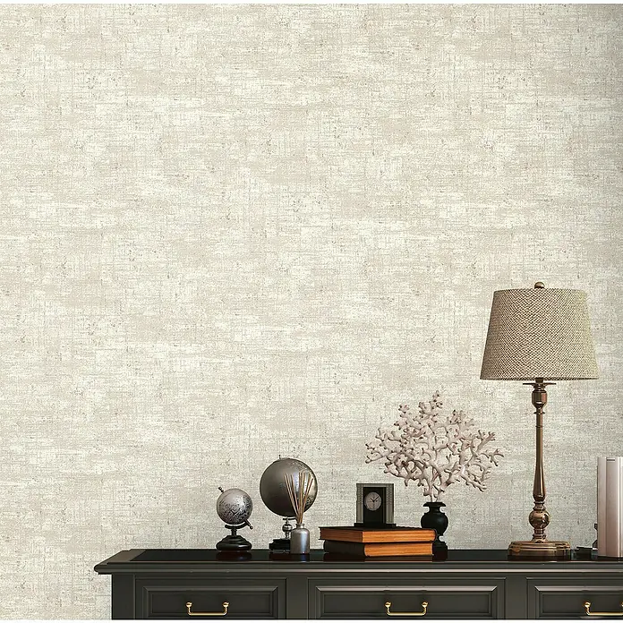A.S. Création Stories of Life Vliestapete - Beige-Weiß-Gold, Uni, 10,05 x 0,53 m - Eine Nahaufnahme von einem eleganten schwarzen Schrank mit Dekorationsgegenständen wie einer Lampe, Globen und Büchern auf der Oberseite.