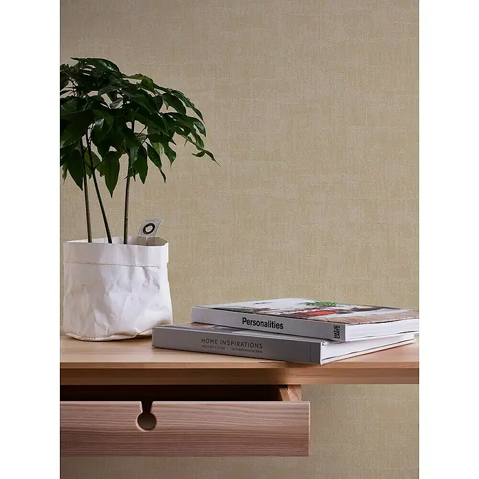A.S. Création Jade 2 Vliestapete - Beige-Taupe, Uni, 10,05 x 0,53 m - Eine elegante Nachttischszene mit einer Zimmerpflanze in einem weißen Übertopf und zwei Büchern, die eine ruhige Atmosphäre schaffen.