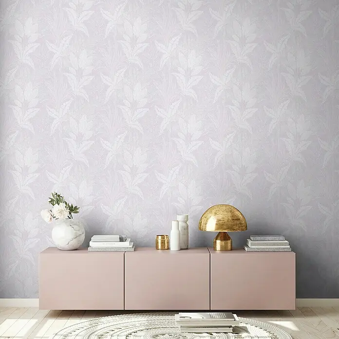 A.S. Création Stories of Life Vliestapete Dschungel - Violett-Weiß-Grau, Floral, 10,05 x 0,53 m - Stilvoller Raum mit rosafarbenem Sideboard, Marmorvase, goldener Lampe und Büchern vor einer eleganten Blümchentapete.